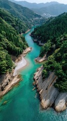 Drone Aerial View Of A Turquoise River Winding Through Lush Green Forested Mountains Under A Clear Blue Sky