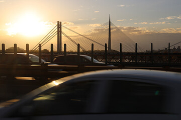 sunset evening red blue orange sky, and blur blurred cars came and went on Ada bridge View from Gazela bridge New Old railway bridge