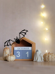 31 october date calendar, decorative pumpkins, ghost, bat on table close up. cozy festive decor for Halloween, Samhain holidays. idea for autumn season interior decoration. soft focus