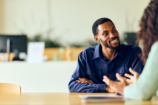 Fototapeta African-American Man in Office Sharing Friendly Conversation With Colleague During Casual Business Meeting