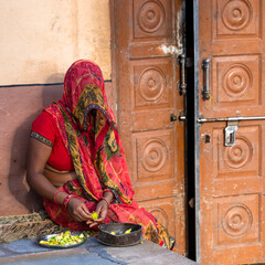 Hindu woman peeling vegetables in a village