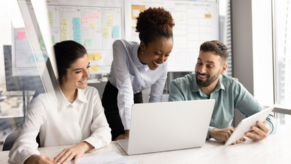 Joyful multicultural business team working on project in modern office