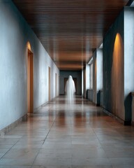 A spectral figure floats through a long, eerily lit hallway.