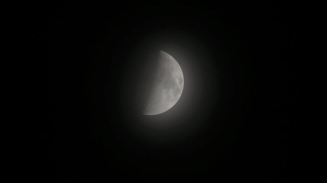 Tokyo, Japan - October 29, 2025: The half moon partially covered with thin clouds
