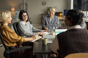 Group of Middle Aged Caucasian and Black Women Collaborating in Office Meeting