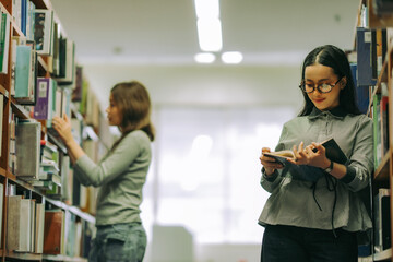Woman finding academic book in university library, depicting education, research skills, and...