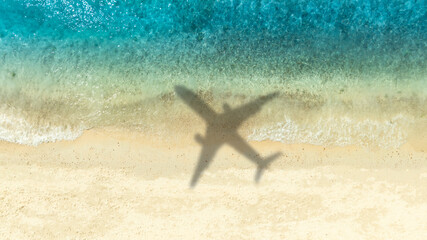 Aerial view of shadow passenger plane silhouette and sandy beach blue sea with waves at sea beach summer vacation sea travel concept	