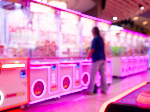 Vibrant Arcade Claw Machine Games with Glowing LED Lights in Indoor Amusement Venue