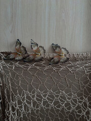 Decorative butterflies with pearl details placed on lace fabric, elegant handmade textile...