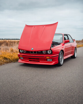 red BMW M3 E30 with opened hood. Three quarter front view of 1980s performance version of BMW 3-series - german sport coupe. Ukraine - October 19 2024