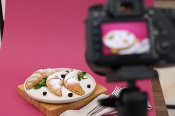 Shooting tasty croissants with camera in studio, selective focus. Professional food photography