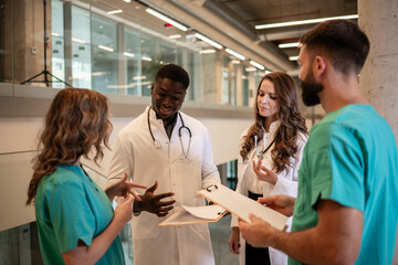 Healthcare team discussing medical records in hospital corridor