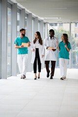 Fototapeta premium Medical team walking and discussing in hospital corridor