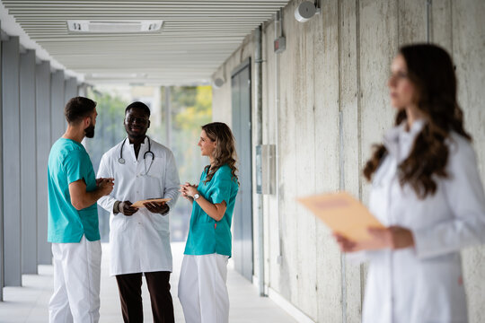 Diverse medical team discussing in hospital hallway