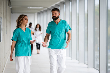 Medical professionals walking and discussing in hospital corridor