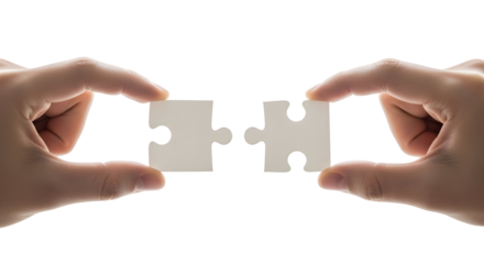 Close-up of human hands about to connect two interlocking jigsaw puzzle pieces, representing synergy, completion, business strategy, and finding the perfect solution for integration