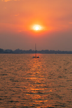 Sunset over the sea, with catamaran in silhouette. View from Coochiemudlo Island, Queensland, Australia