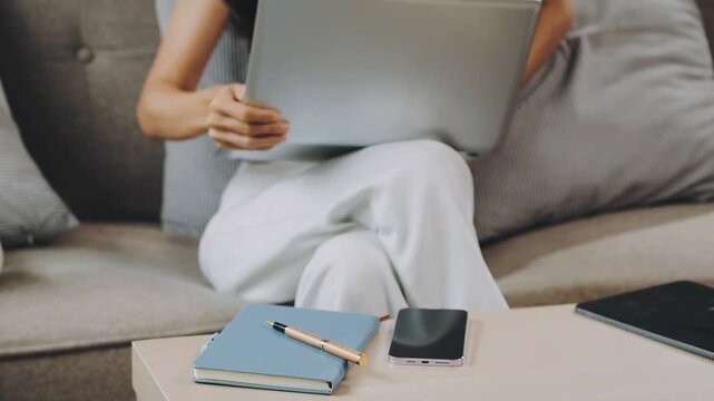 Flexible working. Young woman sitting on sofa using laptop remote work life balance happy home, hybrid, work from home ,remote ,work life balance - Powered by Adobe