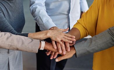 Obraz premium Portrait of a group of business people holding hands together in the office. Teamwork and success concept