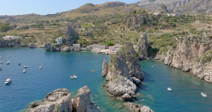 Aerial view of the coast of Scopello, in the province of Trapani, Sicily, Italy. Boats are on vacation around the rocks in the Zingaro Nature Reserve.