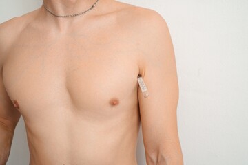 Naklejka premium Man measuring body temperature with thermometer under armpit