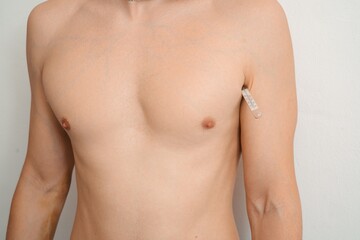 Fototapeta premium Man checking body temperature with thermometer under armpit