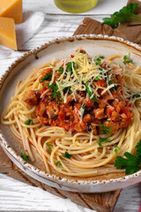 Bolognese pasta with haddock fish mince served with parmesan cheese on ceramic plate. Pescatarian meal. Variation of the classic Italian dish