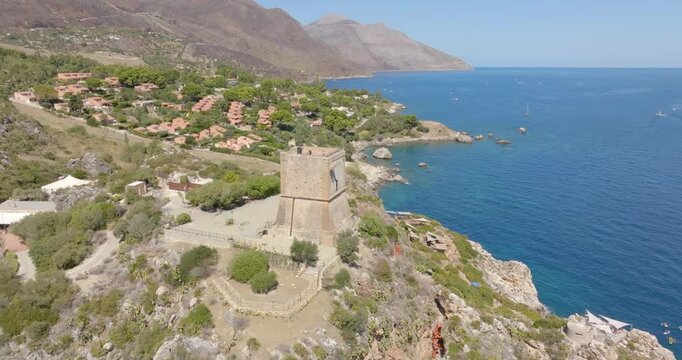 Aerial view of a medieval tower overlooking the Mediterranean Sea. It is located in the Zingaro Nature Reserve in Scopello, in the province of Trapani, Sicily, Italy.