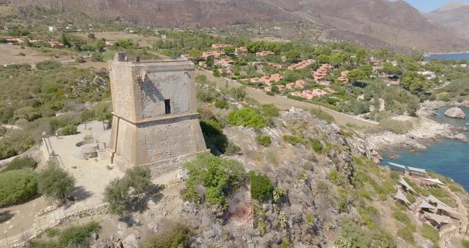Aerial view of a medieval tower overlooking the Mediterranean Sea. It is located in the Zingaro Nature Reserve in Scopello, in the province of Trapani, Sicily, Italy.