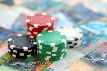 Kuwaiti dinar currency money bills and bunch of casino chips close up. The concept of gambling and casino games