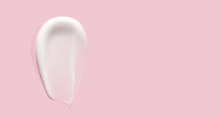 smear of cream texture on a light pink background