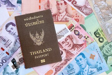 Thai baht currency money bills and passport close up. The concept of travel and vacation