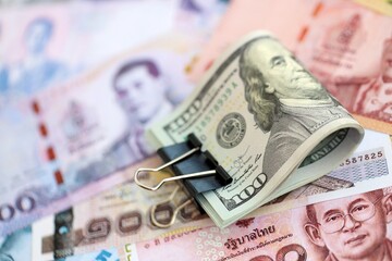 Thai baht currency money bills and bunch of us dollar banknotes close up. The concept of economics and currency exchange