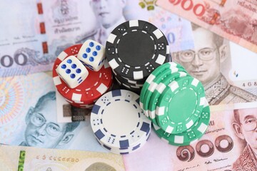 Thai baht currency money bills and casino chips with dices. The concept of gambling and poker casino games