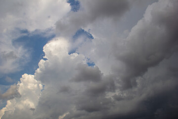 Blue sky with different clouds. White and gray clouds. Natural background