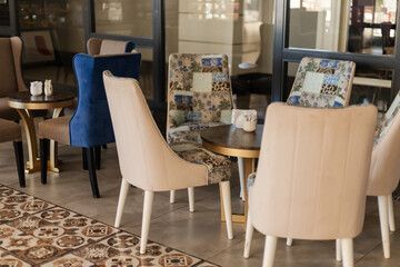 This cozy seating area features modern chairs in soft upholstery and a beautifully patterned floor. Sunlight filters in, creating a warm atmosphere for guests to relax and enjoy