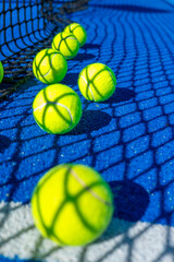 A vertical row of yellow tennis balls on a blue court The Concept of Sports Training