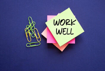 Work Well symbol. Yellow sticky note with words Work Well. Beautiful deep blue background. Business...