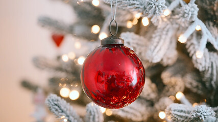 Frosted Christmas tree glowing lights red ornament, festive holiday background, cozy winter decoration, New Year celebration detail, sparkling seasonal decor, traditional Xmas mood, joyful festive