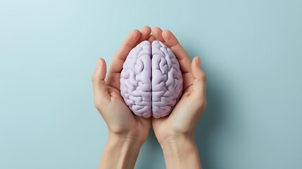 A pair of hands is depicted holding a light purple anatomical brain model against a pastel blue background, representing themes of mental health, mindfulness, and cognitive care.
