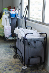Cleaning staff prepare for guest turnover by collecting used linens and supplies from the hotel room. The service ensures a tidy and welcoming environment for visitors