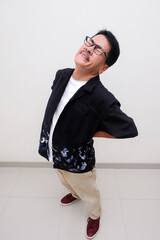 man standing, pressing his painful back, suffering from backache