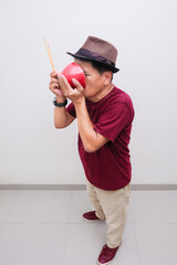 man sipping up soup from bowl covering his face