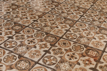 The vintage floor showcases beautifully detailed tile patterns in earthy tones. Each tile displays unique designs, highlighting craftsmanship. Perfect setting for architectural exploration