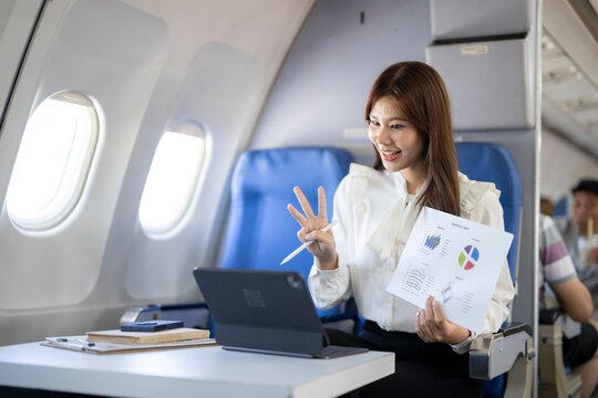 Businesswoman making video call presentation on airplane