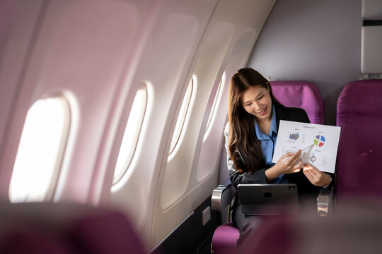 Businesswoman presenting financial charts during airplane travel