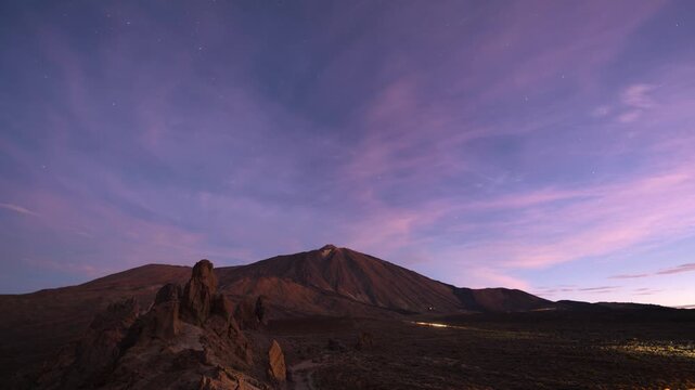 Stunning 4K time lapse showing the transition from night to day over Mount Teide and the iconic Roques de Garcia rock formations in Teide National Park, Tenerife. Vibrant multicolored clouds