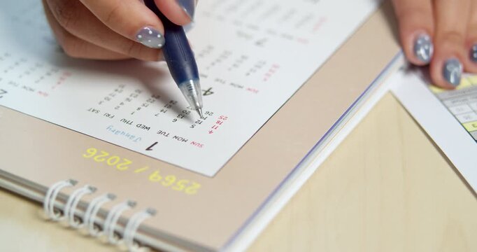 A focused individual meticulously organizes their tasks using a calendar showcasing effective time management.