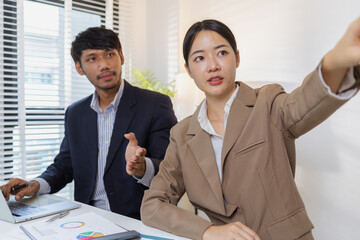 A group of business professionals engaged in a serious office discussion, analyzing financial reports and exchanging ideas to solve problems and make effective corporate decisions.