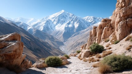 Panoramic Mountain Vista With Snow Capped Peaks And Rocky Terrain Under A Clear Blue Sky With Sunny Daylight Illumination
